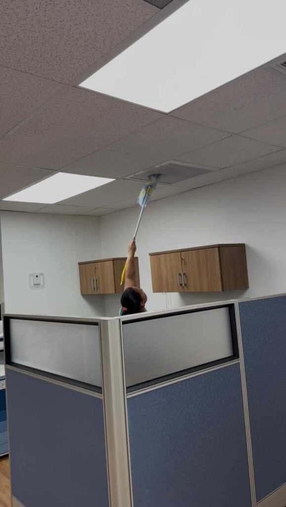 dusting ceiling vent at an office